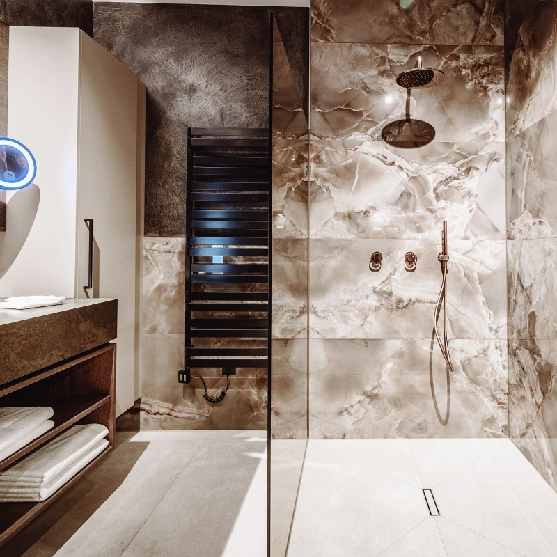 Luxuriöse Regendusche mit Marmorfliesen in den Dillhof Apartments