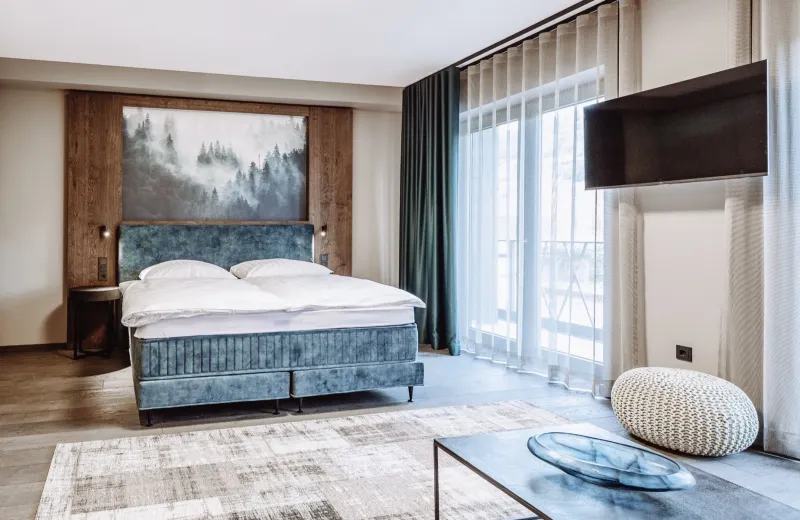 Bedroom of a Dillhof apartment with a view into the Spessart forest